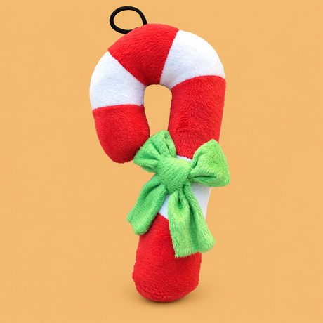 Christmas Candy Cane Plush Dog Toy — isolated product on a warm peach background